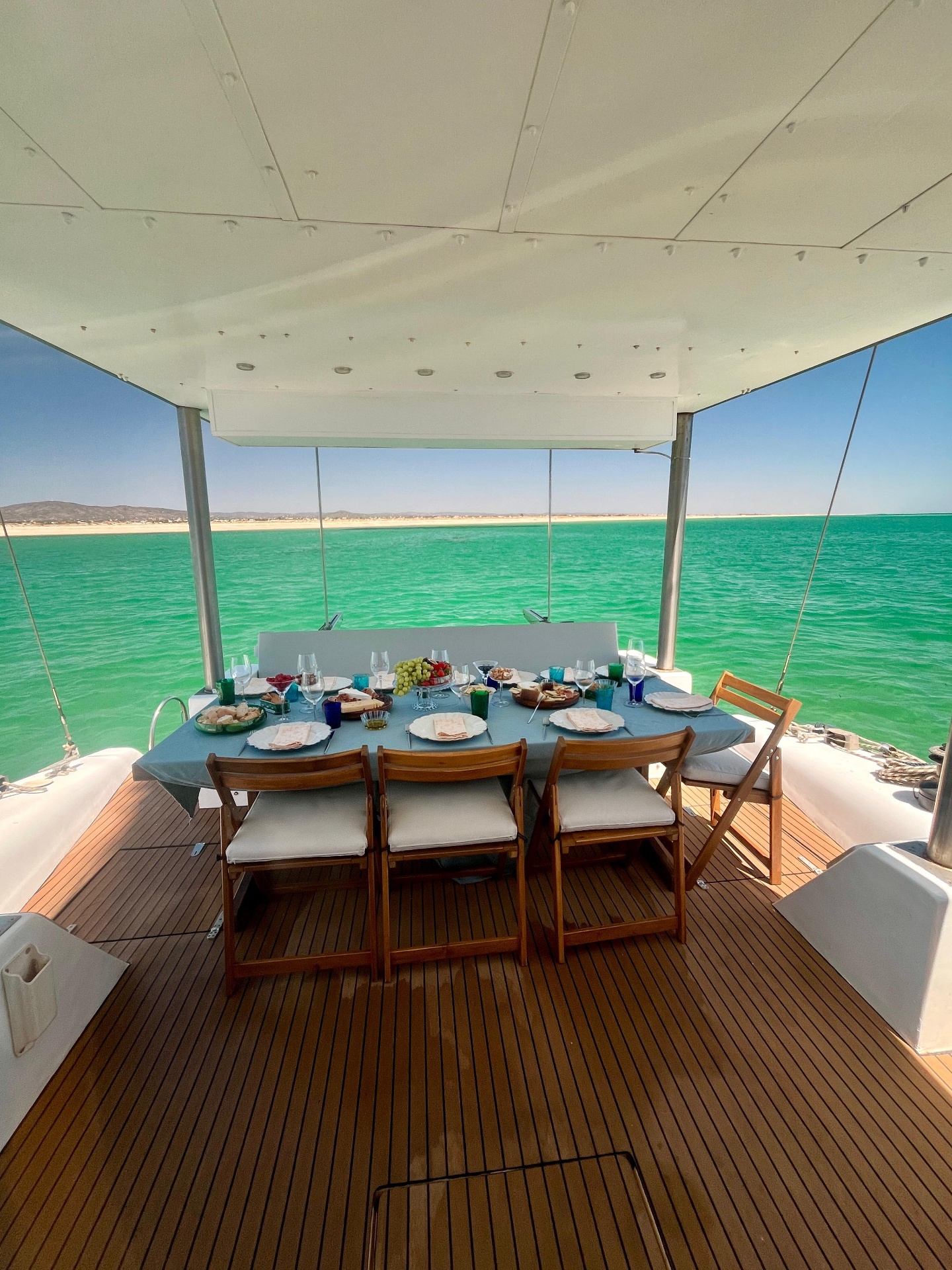 Table set for lunch on the catamaran deck overlooking turquoise water