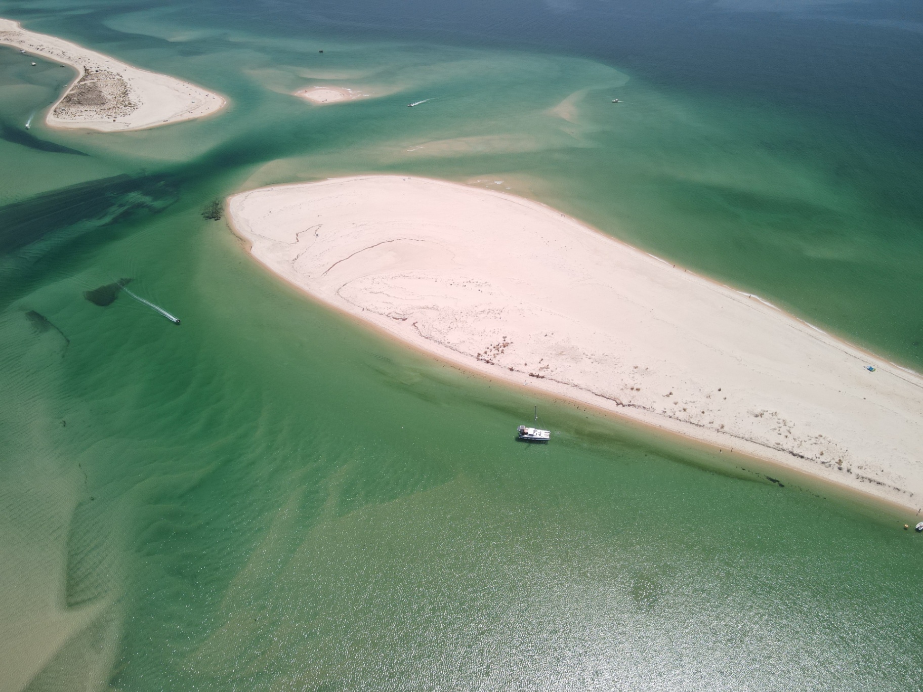Deserted white sandbank island surrounded by turquoise water